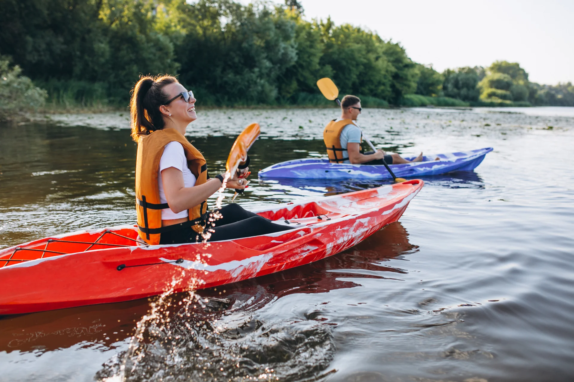 Pareja navegando en kayak por un río tranquilo